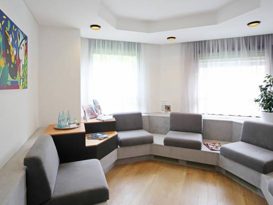 Wartezimmer mit runder Sitzecke in Grau