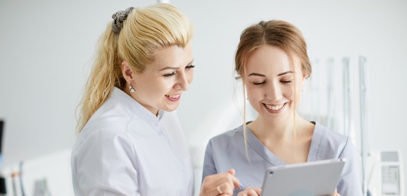 Zahnärztin und junge MFA arbeiten am Tablet